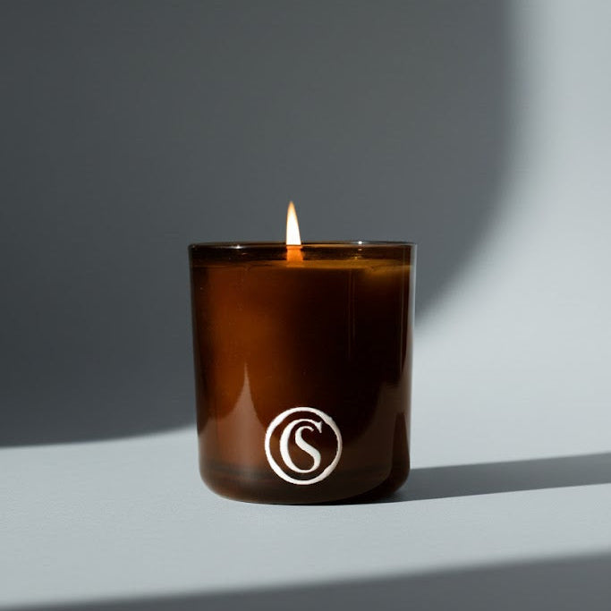 Amber candle with a logo on a blue background